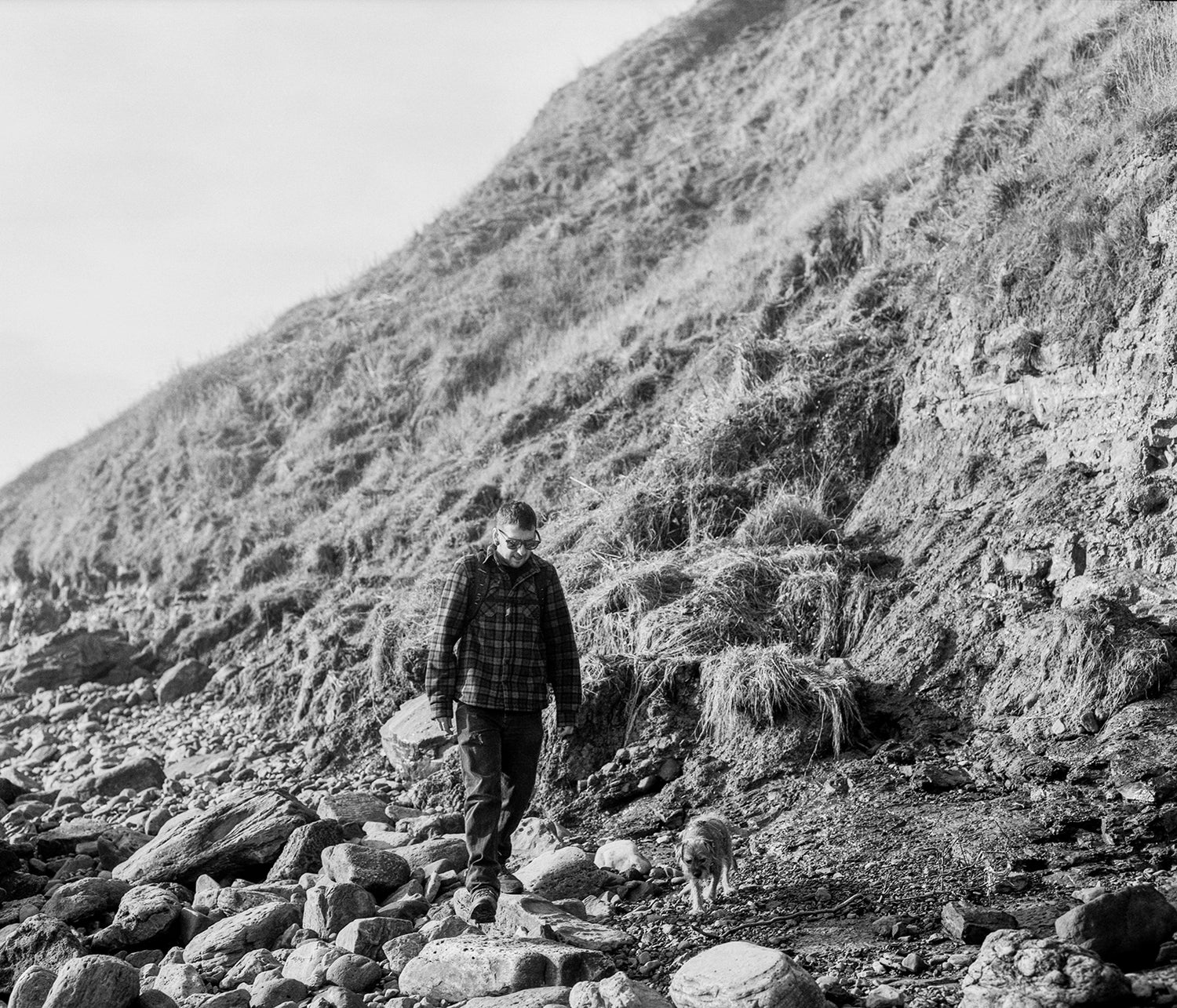 Store owner Mike and his Border Terrier, Percy out looking for dinosaur footprints on the Yorkshire Coast.